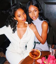 two women sitting next to each other at a table