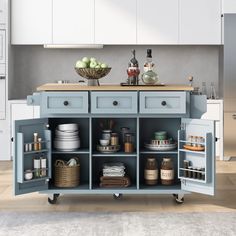 a blue kitchen island with lots of dishes on it and baskets in front of it