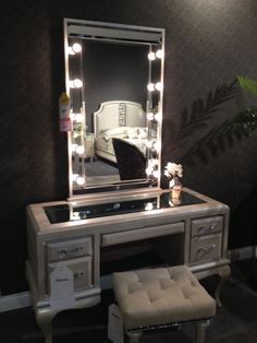 a dressing table with a mirror, stool and lights