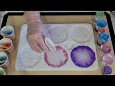 a person in gloves is making art on a tray