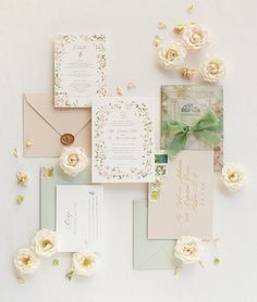 the wedding stationery is laid out with flowers