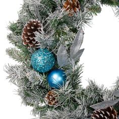 a christmas wreath with pine cones and blue balls on it, surrounded by tinsel