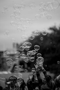 black and white photograph of people blowing bubbles