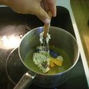 a person stirring something in a pot on the stove