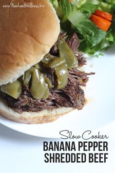 slow cooker banana pepper shredded beef on a bun with lettuce and carrots