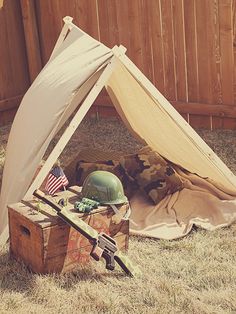 an army helmet sits in the shade of a tent