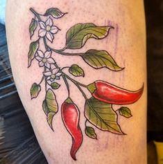 a tattoo on the leg of a woman with chili peppers and leaves