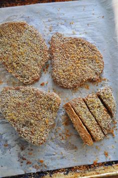 four pieces of bread sitting on top of a piece of parchment paper next to each other