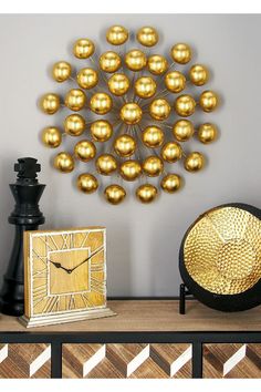 a gold clock sitting on top of a wooden table