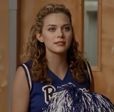 a woman with curly hair wearing a basketball uniform