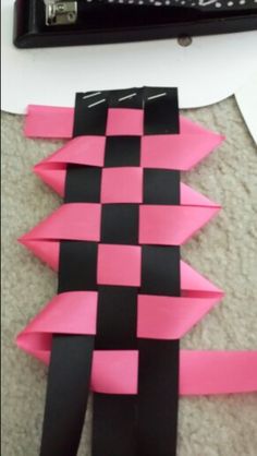 a pink and black piece of paper sitting on top of a floor next to a keyboard