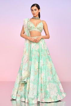 Mint attached can-can and satin lined lehenga with floral bloom print. Paired with a padded blouse with floral print base and all over threads, beads and sequin embroidery. Comes along with a dupatta.
Components: 3
Pattern: Print, Embroidery
Type Of Work: Floral, Stone, Beads
Neckline: V Neck
Sleeve Type: Sleeveless
Fabric: Tabby Silk, Lining: Satin
Color: Green
Other Details: 
Lehenga:
Attached can-can
Attached lining
Length: 44 inches
Stones and thread embroidered waistband
Blouse:
Padded
Dupa Silk Floral Print Sets For Reception, Silk Sets With Floral Print For Reception, Festive Silk Lehenga With Floral Print, Silk Sharara With Floral Print For Reception, Silk Lehenga With Floral Print For Reception, Silk Lehenga With Floral Print For Festivals, Festive Floral Print Silk Lehenga, Festive Organza Lehenga With Floral Print, Fitted Organza Lehenga With Floral Print