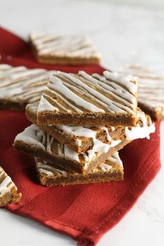 soft glazed gingerbread bars with white frosting are stacked on top of each other