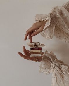 a person holding a small stack of books in their left hand and wearing a white dress