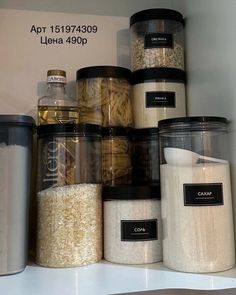 a shelf filled with lots of different types of food in plastic containers and labeled labels