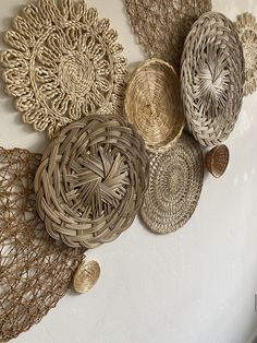 several woven baskets are hanging on the wall