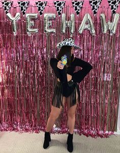 a woman standing in front of a pink backdrop with the words yeehaw on it