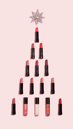 a christmas tree made out of lipsticks and a star ornament on top