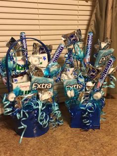 two blue buckets filled with candy and confetti on top of a counter