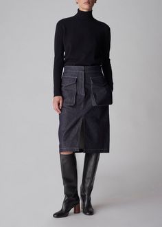 Blending utilitarian flair with feminine sophistication, the cargo pencil skirt is a versatile bottom during the transitional months from summer to early fall. Waist band with metal zip and horn button closure. Center front vent. Front cargo pockets and back flap pockets. 100% Cotton Knee Length Skirt Pencil, Exclusive Dress, Raw Denim, Long Sleeve Turtleneck, Loungewear Shorts, Early Fall, Turtle Neck Top, Designer Clothes For Men, Modern Outfits