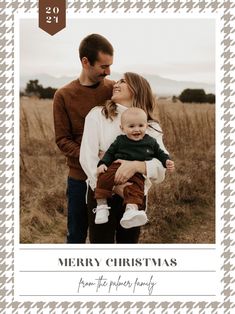 a christmas card with an image of a man and woman holding a baby in their arms