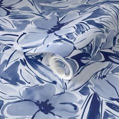 a blue and white floral wallpaper with large flowers on the back side of it