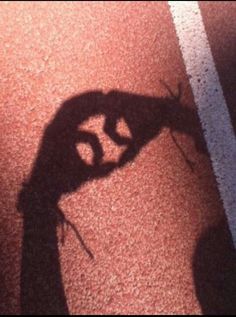 the shadow of a person's hand holding a tennis racquet