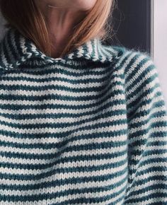 a close up of a person wearing a sweater with stripes on the front and back