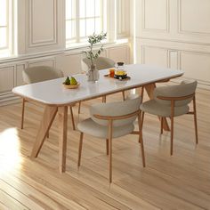 a dining room table with chairs and fruit on the plate next to it, in front of a white paneled wall