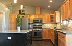 a kitchen with wooden cabinets and stainless steel appliances