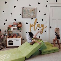 two children playing in a play room with black and white wall decals on the walls