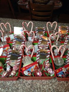 many candy canes and candies are arranged in red boxes on a countertop