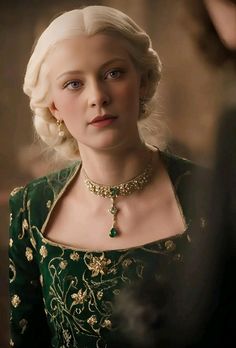 a woman in a green dress and gold jewelry