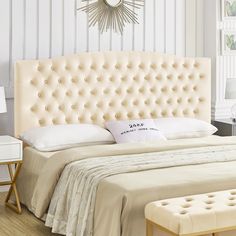 a white bed with an upholstered headboard and foot board