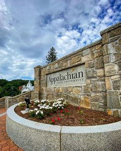 the entrance to appalachan state university with flowers and trees in the background