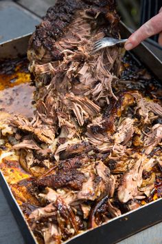 a person is cutting meat with a knife and fork in a pan on a table