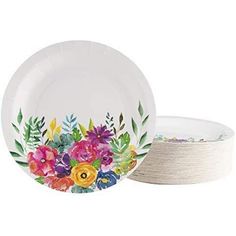 a white plate with colorful flowers painted on the front and side, sitting next to a bowl