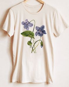 Violet botanical t-shirt - February Birth Flower — Anna Farba Illustration Hand Painted T-shirt, Gardener Fashion, Hand Painted T Shirts, Flower Shirt Design, Birthday In February, Pride Flowers, Celebrate February, February Birth Flower, Flower T Shirt