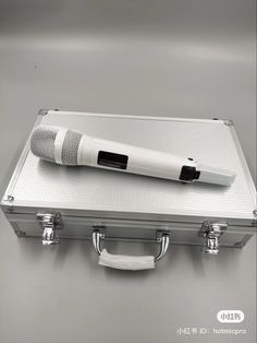 a silver suitcase with a microphone on top