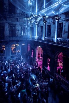 a large group of people standing inside of a building