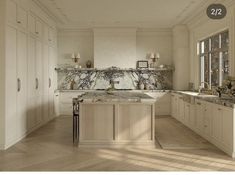 an image of a kitchen setting with marble counter tops and white cabinetry on the walls