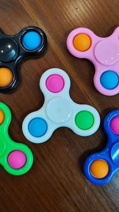 three toy fidgets sitting on top of a wooden table