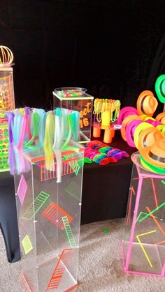 there are many different types of toys on the table together in this photo, including plastic cups and neon colored straws