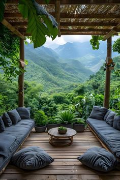 an outdoor living area with couches and tables in front of the mountain range, surrounded by greenery