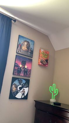 a bedroom with posters on the wall and a cactus