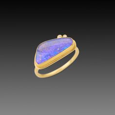 This stunning ring features an organically shaped, magical, Australian opal accented with with two tiny, sparkling diamonds. The gemstone is wrapped in 22k gold and set on a 2mm, 18k gold hammered band. The opal measures approximately 1/4 inch x 3/4 inch. Matte finish. 14k Yellow Gold Opal Ring With Gemstone Accents, Unique Yellow Gold Ethiopian Opal Ring, Unique Ethiopian Opal Rings In Yellow Gold, Luxury Handmade Opal Ring Fine Jewelry, Luxury Artisan Handmade Opal Ring, Luxury Opal Rings With Polished Finish, Luxury Multi-stone Opal Ring In 14k Gold, Adjustable Hand-strung Opal Jewelry, Boulder Opal Ring