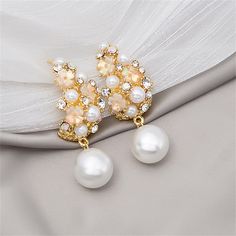 Take your accessory style up a notch with these drop earrings that feature a romantic floral motif and round pearls for a luxe look. 0.71" W x 1.96" L 18k gold-plated copper / cubic zirconia / pearl / acrylic A Romantic, Floral Motif, Cubic Zirconia, 18k Gold, Pearl Earrings, Gold Plate, Plating, Copper, Drop Earrings