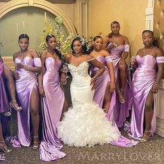 a group of women standing next to each other wearing purple dresses and holding wine glasses