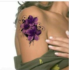 a woman's shoulder with purple flowers painted on the back of her arm and chest