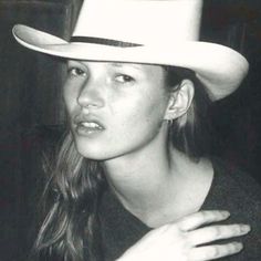 black and white photograph of a woman wearing a cowboy hat with one hand on her hip